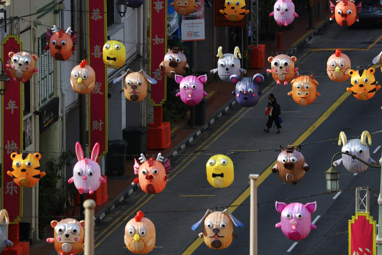 A pedestrian wearing a protective mask crosses a street decorated with Chinese zodiac lanterns at Chinatown on February 9, 2021 in Singapore.  (Photo by Suhaimi Abdullah/NurPhoto via Getty Images)