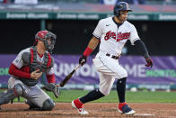Cleveland Indians' Cesar Hernandez watches his three-run triple next to Cincinnati Reds catcher Tyler Stephenson the fourth inning of a baseball game Saturday, May 8, 2021, in Cleveland. (AP Photo/Tony Dejak)