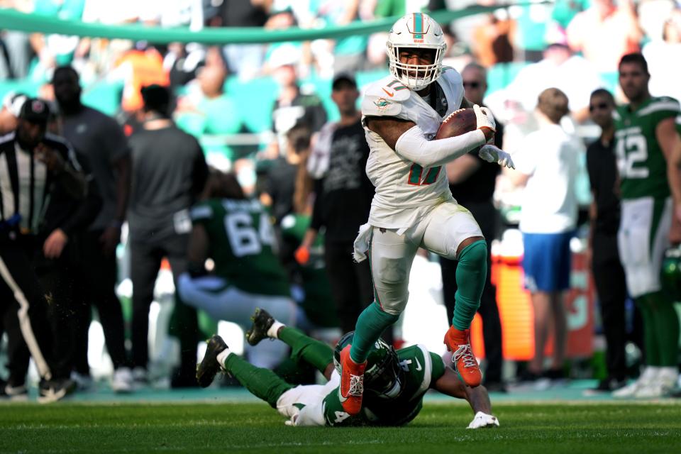 Miami Dolphins wide receiver Jaylen Waddle (17) catches a pass over New York Jets cornerback D.J. Reed (4) for a touchdown during the first half of an NFL game at Hard Rock Stadium in Miami Gardens, Dec. 17, 2023.