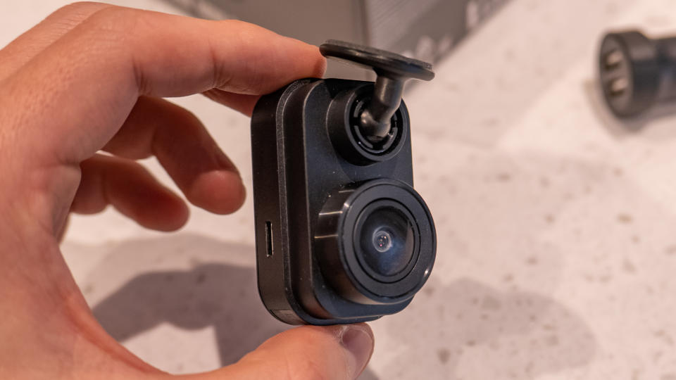 A hand holding the Garmin Dash Cam Mini 2 dash cam