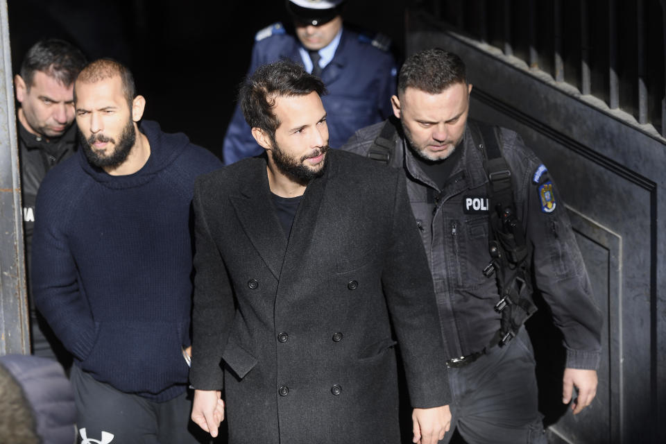 Former kickboxer Andrew Tate (L) and his brother Tristan (2nd R) leave court with police cars after their trial in Bucharest, Romania on February 01, 2023. / Credit: Alex Nicodim/Anadolu Agency via Getty Images