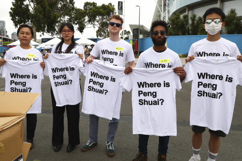 FILE - Supporters of Chinese tennis player Peng Shuai hold up T-shirts ahead of the women's final at the Australian Open tennis championships in Melbourne, Australia, Saturday, Jan. 29, 2022. The women’s professional tennis tour will bring its events back to China later this year, announcing on Thursday, April 13, 2023, the end of a boycott instituted in late 2021 over concerns about the safety of former player Peng Shuai after she accused a high-ranking government official there of sexual assault. (AP Photo/Tertius Pickard, File)