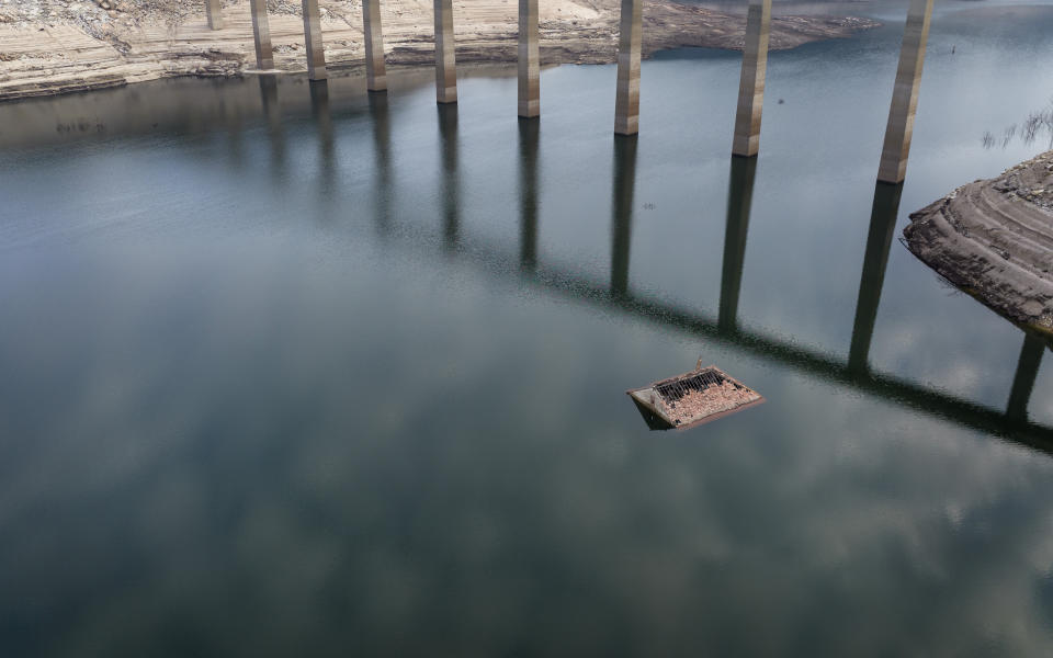 The roof of an old house, submerged three decades ago when a hydropower dam flooded the valley, is photographed emerged due to drought at the Lindoso reservoir, in northwestern Spain, Saturday, Feb. 12, 2022. Large sections of Spain are experiencing extreme or prolonged drought, with rainfall this winter at only one-third of the average in recent years. The situation is similar in neighboring Portugal, where 45% of the country is now enduring “severe” or “extreme” drought. (AP Photo/Emilio Morenatti)