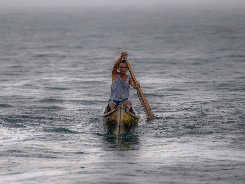 A Guna man paddles toward the island of Carti Sugtupu.