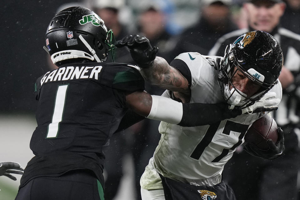 Jacksonville Jaguars tight end Evan Engram (17) stiff-arms New York Jets cornerback Sauce Gardner (1) during the third quarter of an NFL football game, Thursday, Dec. 22, 2022, in East Rutherford, N.J. (AP Photo/Seth Wenig)