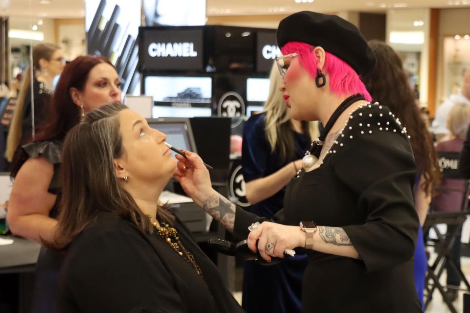 Amanda Dawson gets some makeup tips from Shauna Pierce during the grand opening of the Women's Dillard's at Westgate Mall Thursday morning.