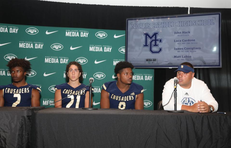 East Rutherford, NJ August 8, 2023 -- Matt Lahoe, Luca Cardone, James Conigliaro and coach John Hack of Morris Catholic answer questions from the media at the high school football Super Football Conference Media Day at MetLife Stadium.