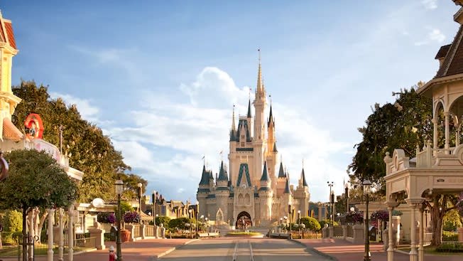 Cinderella's Castle and surrounding area at a Disney domestic theme park with blue sky in background.