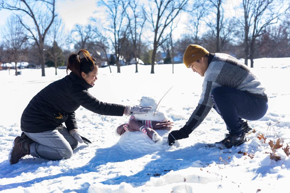 Theresa Zantua, left, and Andre Zantua, right, make a snowman at Overton Park on Wednesday, Jan. 17, 2024. The Memphis area received between 3 to 6 inches of snow and below-freezing temperatures.