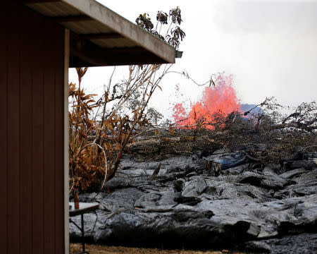 As a volcanic fissure spurts molten rock into the air, lava slowly approaches a home on Nohea Street in the Leilani Estates near Pahoa, Hawaii, U.S., May 27, 2018. REUTERS/Marco Garcia