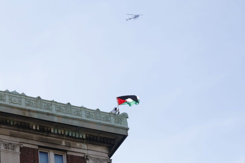 The flag of Palestine is waved from the roof of Hamilton Hall at Columbia University in New York City on Tuesday as protestors stormed the building. They were cleared out later in the night by NYPD at the request of University President Minouche Shafik. Photo by John Angelillo/UPI