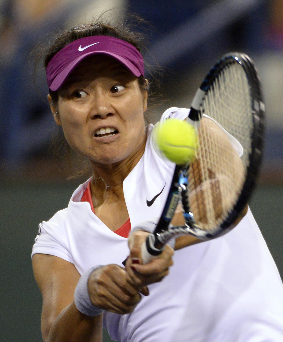 Li Na, of China, returns a shot to Flavia Pennetta, of Italy, at the BNP Paribas Open tennis tournament, Friday, March 14, 2014, in Indian Wells, Calif. (AP Photo/Mark J. Terrill)