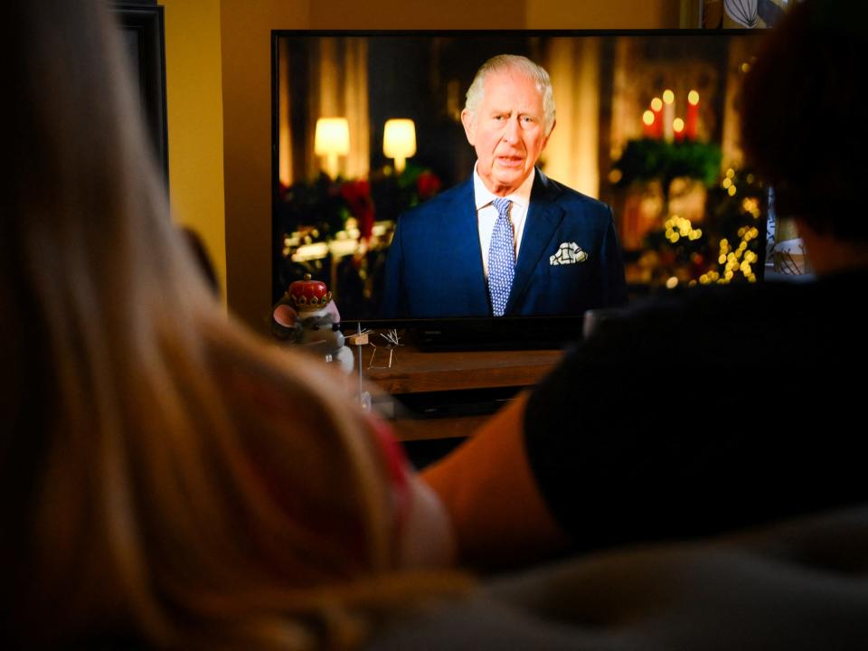A family sits in a living room in Liverpool, as they watch Britain's King Charles III delivering his first annual Christmas Day message, on television, on December 25, 2022.