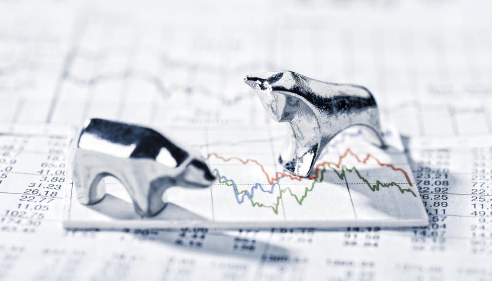 Bear and bull figurines on top of a stock chart.