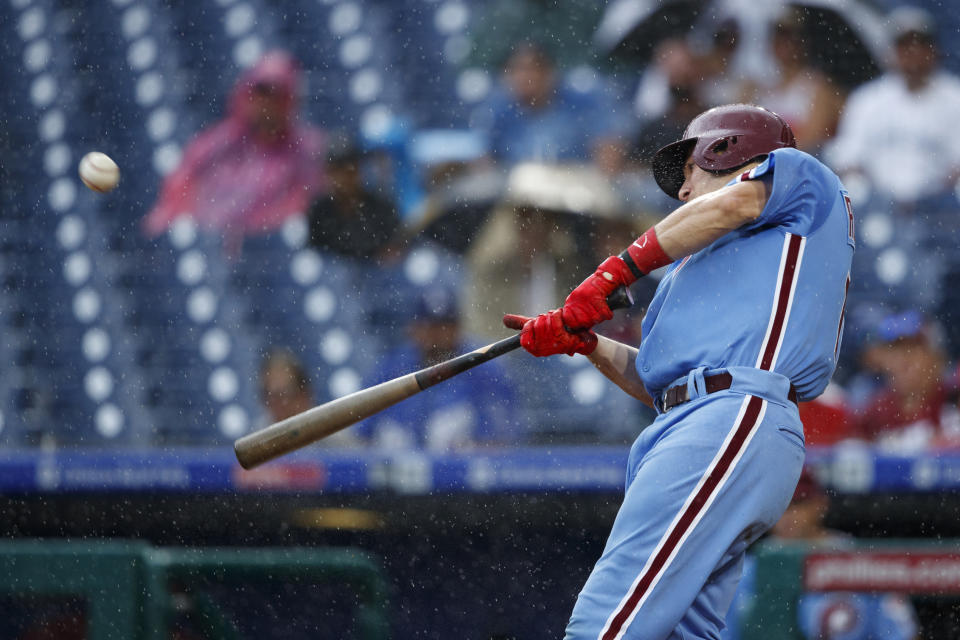 Philadelphia Phillies' J.T. Realmuto hits an RBI-sacrifice fly off Los Angeles Dodgers starting pitcher Ross Stripling during the third inning of a baseball game, Thursday, July 18, 2019, in Philadelphia. (AP Photo/Matt Slocum)