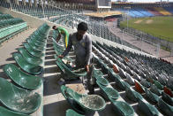 In this Monday, Feb. 17, 2020, photo, workers replace broken seats at Gaddafi stadium in preparation for upcoming Pakistan Super League, in Lahore, Pakistan. Security concerns stopped foreign cricketers from touring Pakistan four years ago when the country's premier domestic Twenty20 tournament was launched, forcing organizers to stage the event on neutral turf in the United Arab Emirates. When the 2020 edition of the PSL starts in Karachi on Thursday, Darren Sammy of the West Indies and Shane Watson of Australia will be among 36 foreign cricketers involved in the six franchises. (AP Photo/K.M. Chaudary)