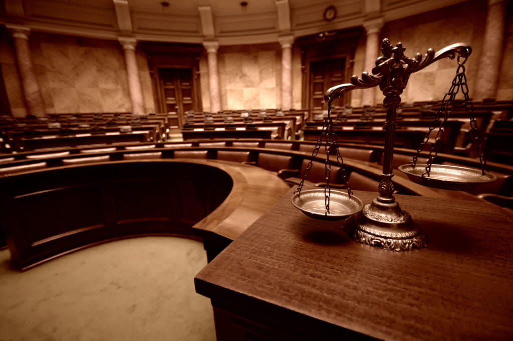 Symbol of law and justice in the empty courtroom. (Adobe Stock)
