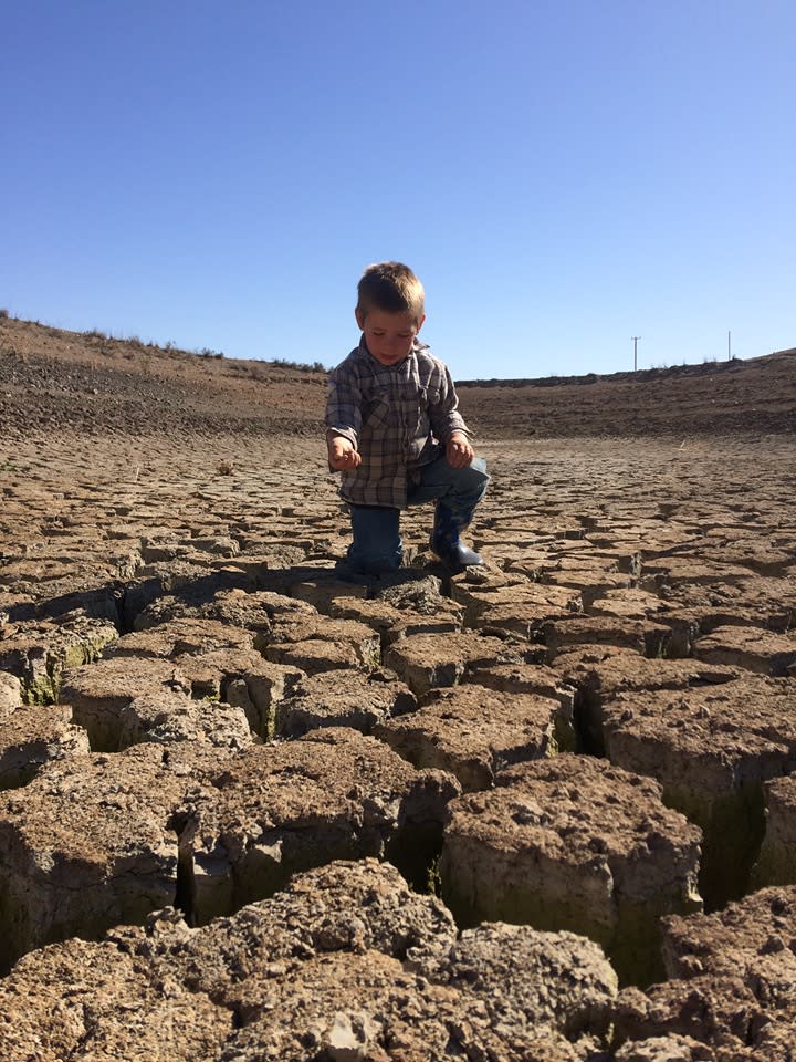 Pictured is four-year-old Noah McArthur inside a dried out dam. His mother says he cannot remember the sound of rain.