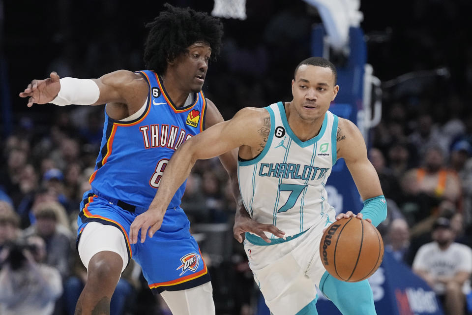 Charlotte Hornets guard Bryce McGowens (7) drives past Oklahoma City Thunder forward Jalen Williams (8) in the first half of an NBA basketball game Tuesday, March 28, 2023, in Oklahoma City. (AP Photo/Sue Ogrocki)