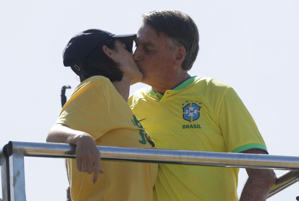 Brazil's former President Jair Bolsonaro, right, kisses his wife Michelle during a demonstration calling for freedom of expression, spurred by Brazilian court orders to suspend accounts on the social media platform X, in Copacabana beach, Rio de Janeiro, Brazil, Sunday, April 21, 2024. (AP Photo/Bruna Prado)