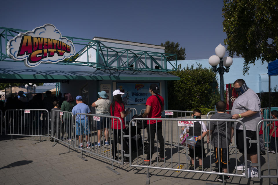 People wait in line to enter Adventure City amusement park on the day of reopening in Anaheim, Calif., Friday, April 16, 2021. The family-run amusement park that had been shut since March last year because of the coronavirus pandemic reopened on April 16. (AP Photo/Jae C. Hong)