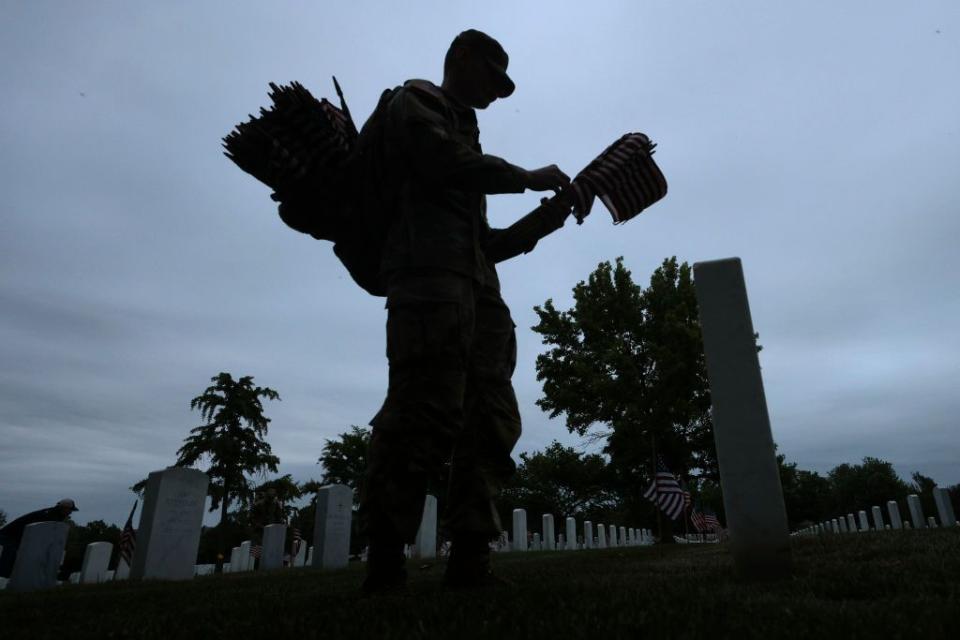 ARLINGTON, VIRGINIA - MAY 25: Members of the 3rd U.S. Infantry Regiment place flags at the headstones of U.S. military personnel buried at Arlington National Cemetery, in preparation for Memorial Day, on May 25, 2023 in Arlington, Virginia. More than 1000 service members entered the cemetery at pre-dawn hours to begin the process of placing a flag in front of more than 270,000 headstones. (Photo by Win McNamee/Getty Images)