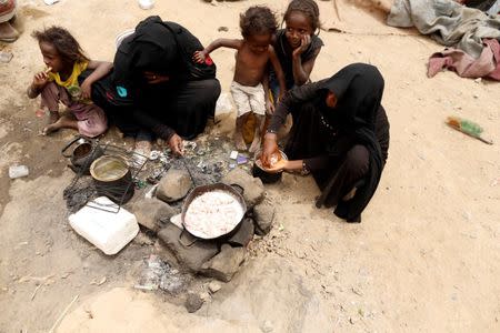 Women displaced from the Red Sea port city of Hodeidah cook a meal outside a house where they live on the outskirts of Sanaa, Yemen July 10, 2018. REUTERS/Khaled Abdullah