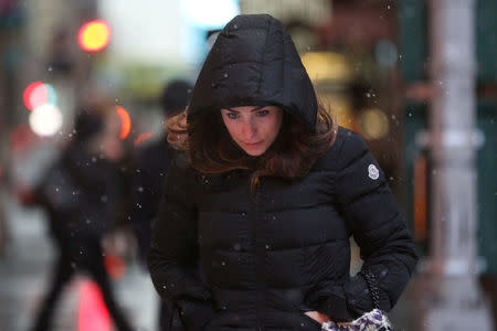 A woman walks as snow falls in Times Square in Manhattan in New York, U.S., March 7, 2018. REUTERS/Amr Alfiky