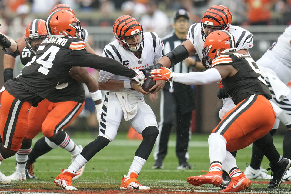 Cincinnati Bengals quarterback Joe Burrow, center, is pressured by Cleveland Browns defensive end Ogbo Okoronkwo (54) during the first half of an NFL football game Sunday, Sept. 10, 2023, in Cleveland. (AP Photo/Sue Ogrocki)