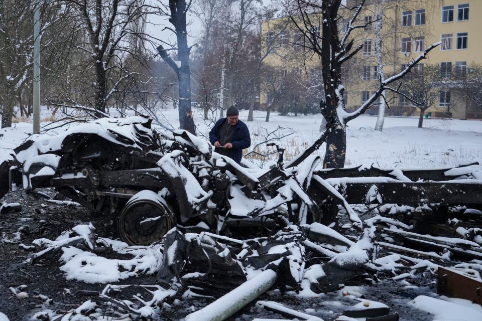 A man photographs smoldering Russian military vehicles destroyed on the outskirts of Kharkiv, Ukraine, on Feb. 25.