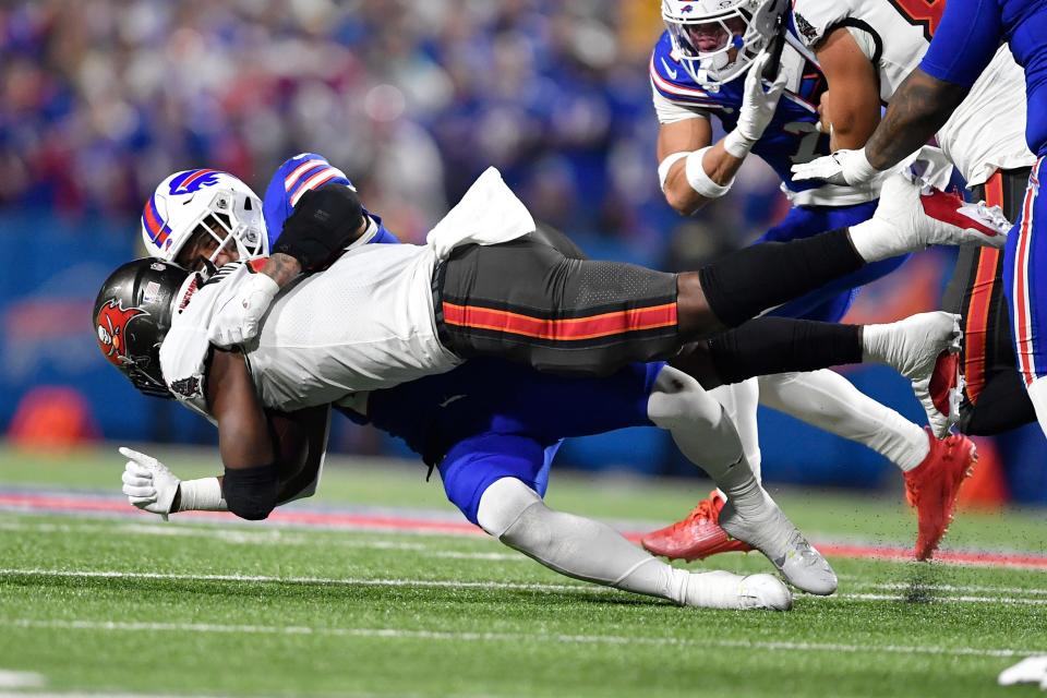 Tampa Bay Buccaneers running back Rachaad White, front, is tackled by Buffalo Bills safety Jordan Poyer, rear, in the first half of an NFL football game, Thursday, Oct. 26, 2023, in Orchard Park, N.Y. (AP Photo/Adrian Kraus)