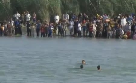 A still image from video released June 6, 2016 shows Iraqi families attempting to escape the besieged city of Falluja, Iraq, by crossing the Euphrates river, June 3, 2016. via REUTERS TV