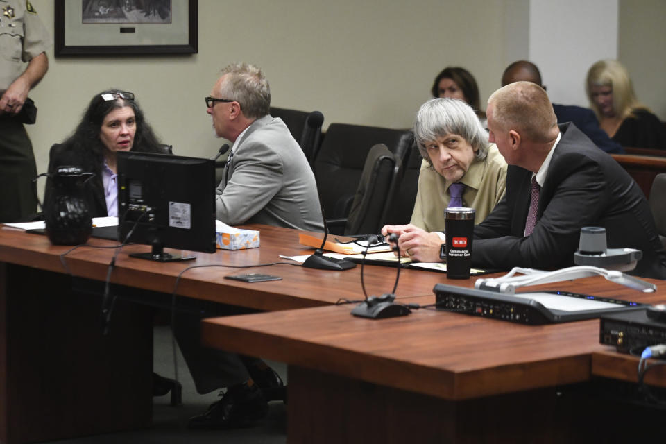 David Turpin, second from right, and wife, Louise, left, talk to their attorneys during a sentencing hearing Friday, April 19, 2019, in Riverside, Calif. The California couple who pleaded guilty to years of torture and abuse of 12 of their 13 children have been sentenced to life in prison with possibility of parole after 25 years. (Will Lester/The Orange County Register via AP, Pool)
