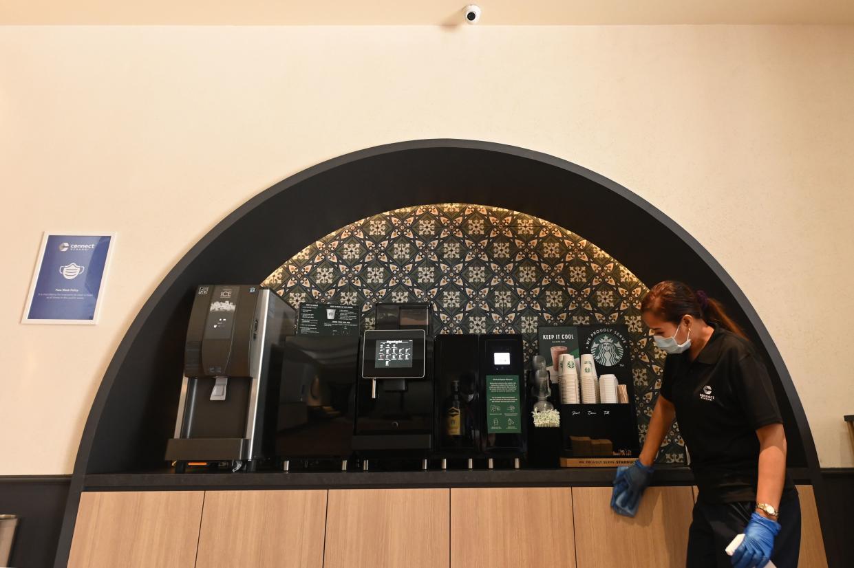 A housekeeper cleans the reception lobby area pantry at Connect@Changi in Singapore.