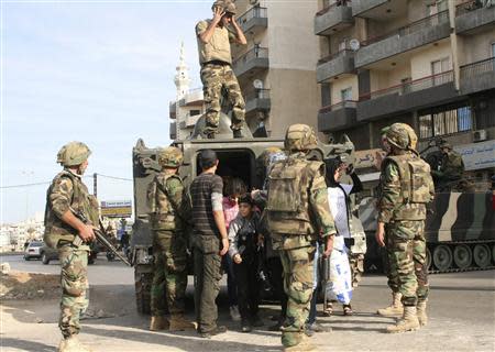 Residents disembark from a Lebanese armoured vehicle after being moved to a safer location in Tripoli, northern Lebanon, November 30, 2013. REUTERS/Stringer