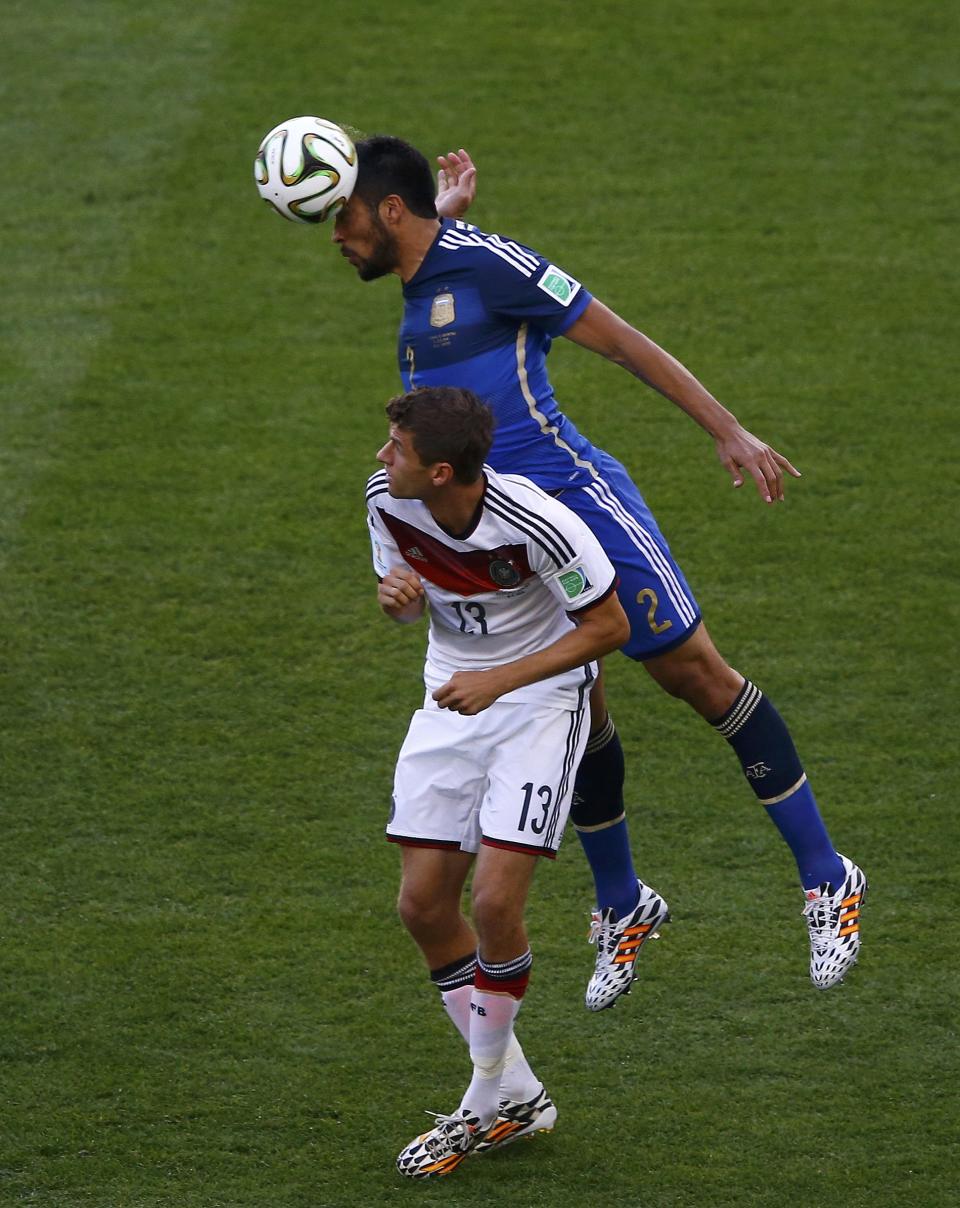 Germany's Thomas Mueller and Argentina's Ezequiel Garay (top) fight for the ball during their 2014 World Cup final at the Maracana stadium in Rio de Janeiro July 13, 2014. REUTERS/Ricardo Moraes (BRAZIL - Tags: SOCCER SPORT WORLD CUP)