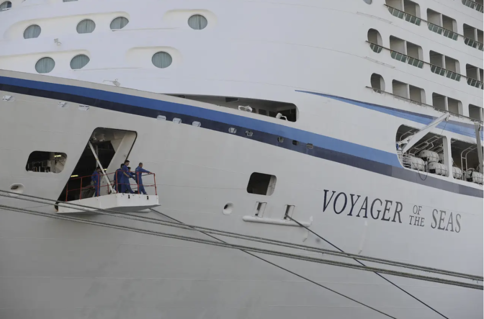 Besatzungsmitglieder des Kreuzfahrtschiffs "Voyager of the Seas" schauen am 1. August 2009 im Hafen von Marseille in Südostfrankreich von der Gangplanke. - Copyright: PATRICK VALASSERIS/AFP via Getty Images