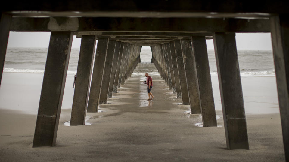 Danny James walks under the Tybee Island pier with a hat full of sea shells he collected during low tide as Hurricane Dorian passes 80 miles out to sea, Sept. 5, 2019, in Tybee Island, Ga. (Photo: Stephen B. Morton/AP)