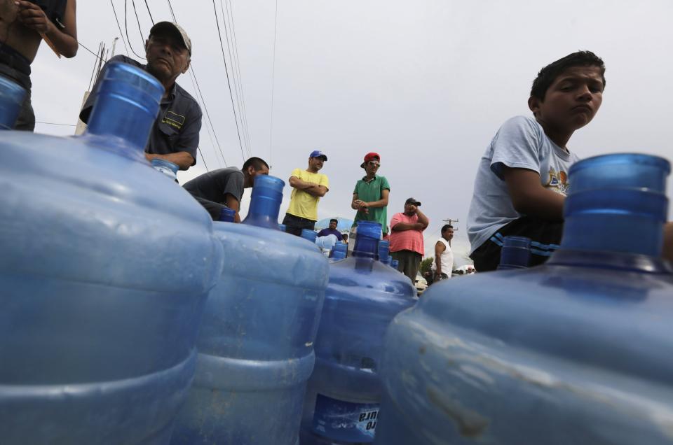 People wait in line to buy bottles of water in San Jose del Cabo, after Hurricane Odile hit Baja California September 19, 2014. Mexico sent in troops and police to safeguard thousands of tourists stranded in the storm-battered Mexican Pacific resort of Los Cabos on Thursday after widespread looting. Odile churned into the southern tip of the Baja California peninsula on Sunday as a Category 3 hurricane, wreaking havoc on a scenic area popular with U.S. sun seekers that has rarely witnessed such devastation. REUTERS/Henry Romero (MEXICO - Tags: ENVIRONMENT SOCIETY)