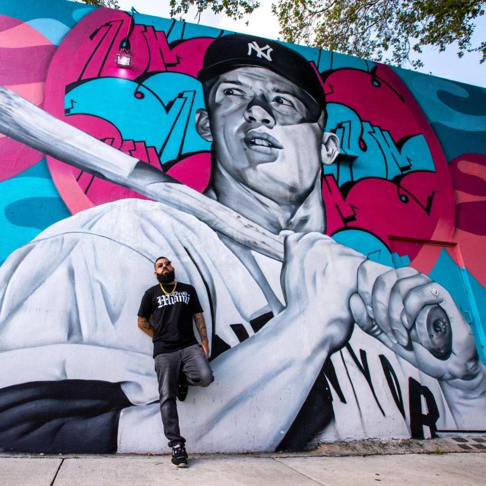 El artista de graffiti Disem se para frente a un mural que pintó del ex lanzador de los Yankees de Nueva York, Mickey Mantle, en Miami, Florida, el jueves 14 de julio de 2022. La pintura es parte de una serie encargada por Yunel Escobar, ex campocorto de la MLB. .