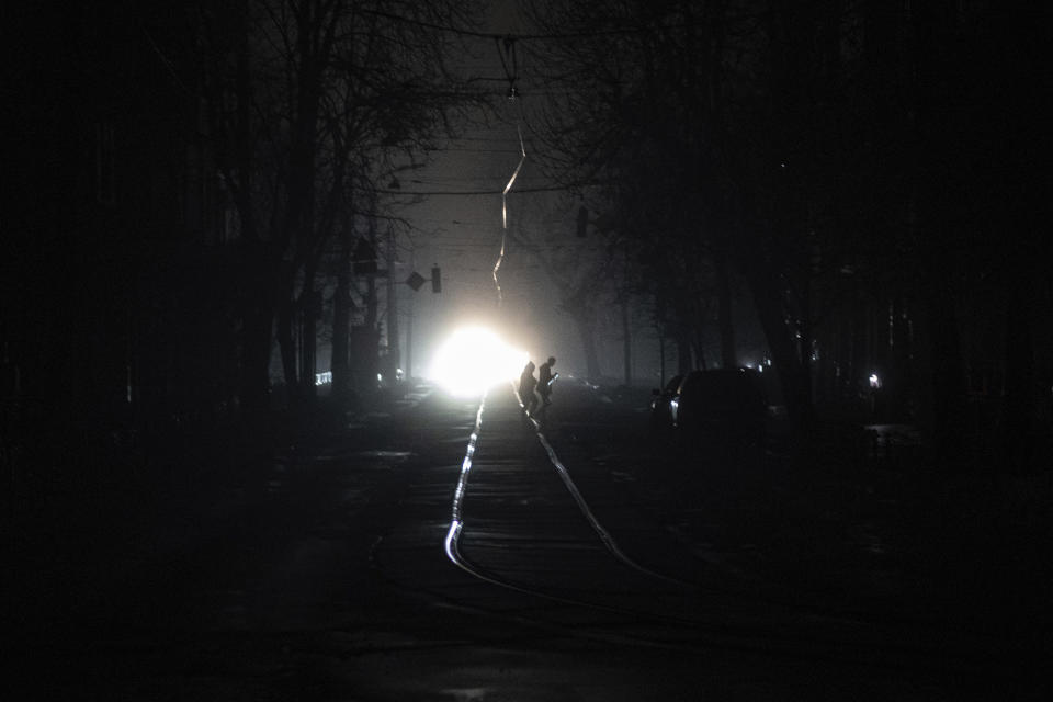 People cross the road at the city center which lost electrical power after yesterday's Russian rocket attack in Kyiv, Ukraine, Thursday, Nov. 24, 2022. (AP Photo/Evgeniy Maloletka)