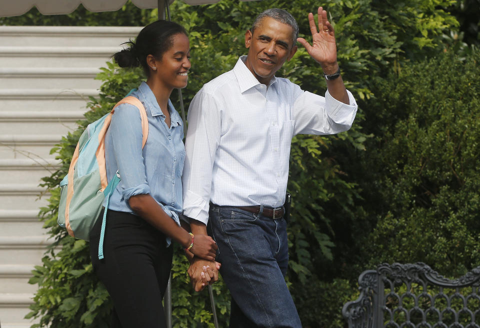 President Barack Obama waves to reporters as he walks with his daughter Malia on the South Lawn of the White House in Washington, Tuesday, Aug. 19, 2014.