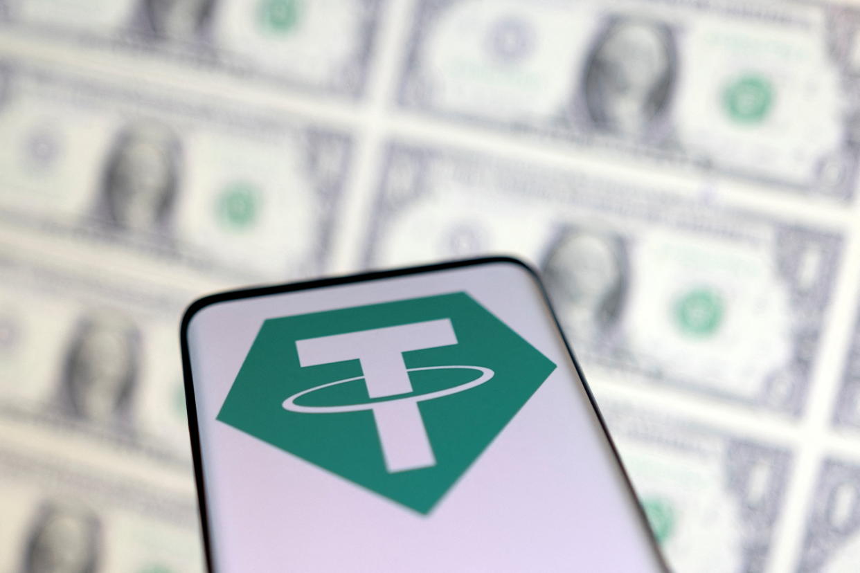 Smartphone with Tether logo is placed on displayed U.S. dollars in this illustration taken, May 12, 2022. REUTERS/Dado Ruvic/Illustration