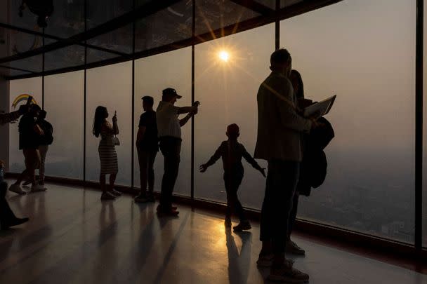 PHOTO: People take photographs as a smokey Toronto is seen from the CN Tower as wildfires in Ontario and Quebec continue to burn, in Toronto, June 6, 2023. (Carlos Osorio/Reuters)