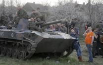 Soldiers of the Ukrainian Army sit a top combat vehicles as they are blocked by people on their way to the town of Kramatorsk on Wednesday, April 16, 2014. The central government has so far been unable to rein in the insurgents, who it says are being stirred up by paid operatives from Russia and have seized numerous government facilities in at least nine eastern cities to press their demands for broader autonomy and closer ties with Russia. (AP Photo/Efrem Lukatsky)