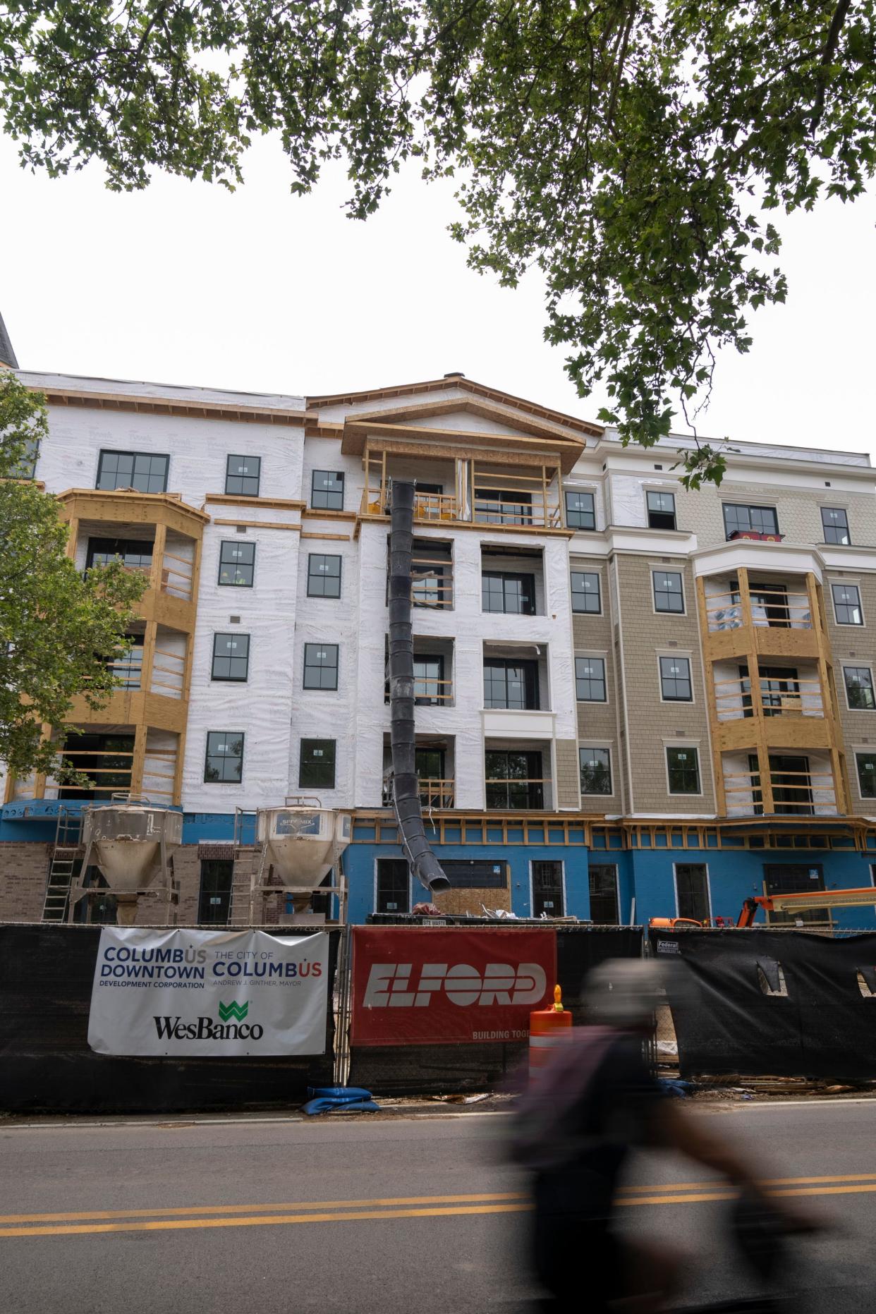 A bicyclist rides down East Town Street past Topiary Park Crossing, a new affordable housing development that is under construction. According to Columbus Downtown Development Corporation’s website, Topiary Park Crossing will feature 98 units that will be rented to qualifying residents based on area median income.