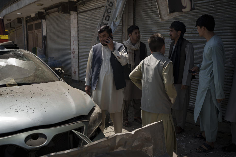 Afghans gather at the site of an explosion in Kabul, Afghanistan, Saturday, Sept. 18, 2021. A sticky bomb exploded in the capital Kabul wounding a few people, said police officials. (AP Photo/Felipe Dana)