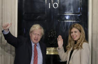 Britain's Prime Minister Boris Johnson and his partner Carrie Symonds wave from the steps of number 10 Downing Street in London, Friday, Dec. 13, 2019. Prime Minister Boris Johnson's Conservative Party has won a solid majority of seats in Britain's Parliament — a decisive outcome to a Brexit-dominated election that should allow Johnson to fulfill his plan to take the U.K. out of the European Union next month. (AP Photo/Matt Dunham)