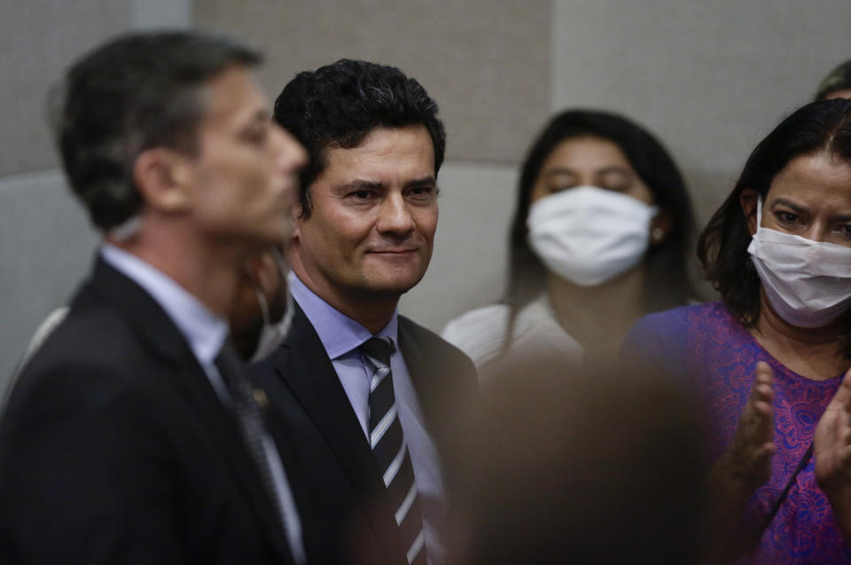 Brazil's Justice Minister Sergio Moro, second from left, stands after announcing his resignation at a press conference in Brasilia, Brazil, Friday, April 24, 2020. Moro made the announcement after President Jair Bolsonaro decided to change the head of the country's federal police. (AP Photo/Eraldo Peres)