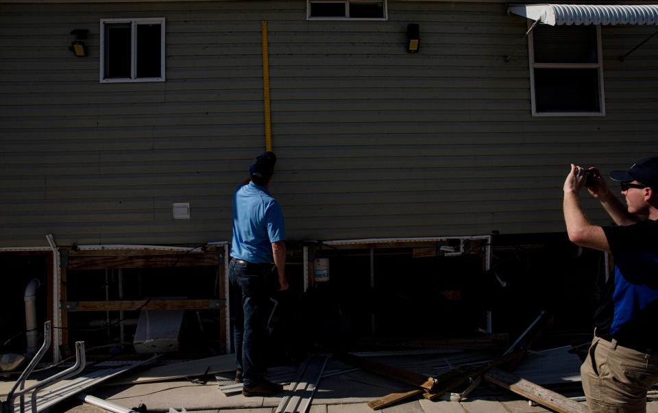 Rodney Wynn and Austen Flannery, both meteorologist for the National Weather Service assess Hurricane Ian damage including storm surge heights on homes on San Carlos Island next to Fort Myers Beach on Tuesday, Oct. 4, 2022. 